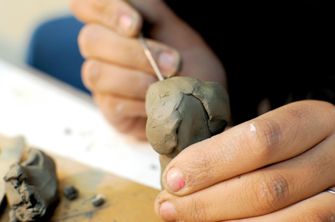 person sculpting clay figure