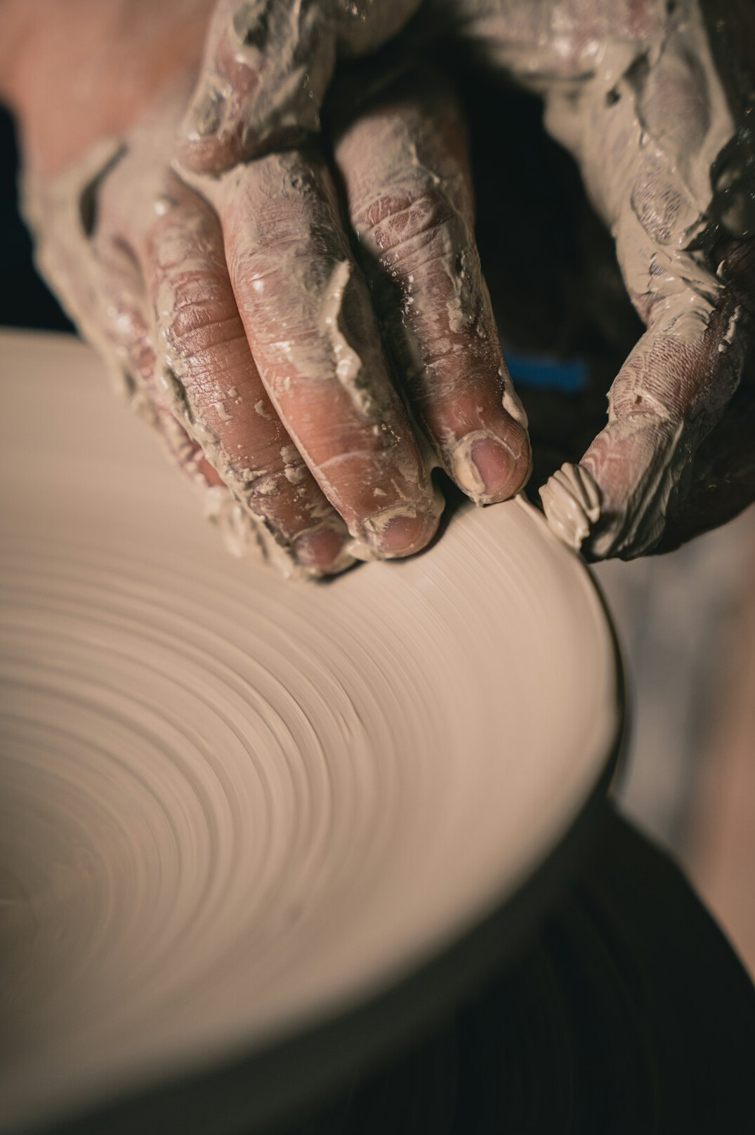 potter shaping clay on wheel